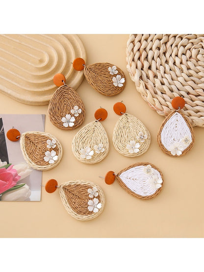 Close-up of Earedge raffia woven teardrop shaped earrings on white background
