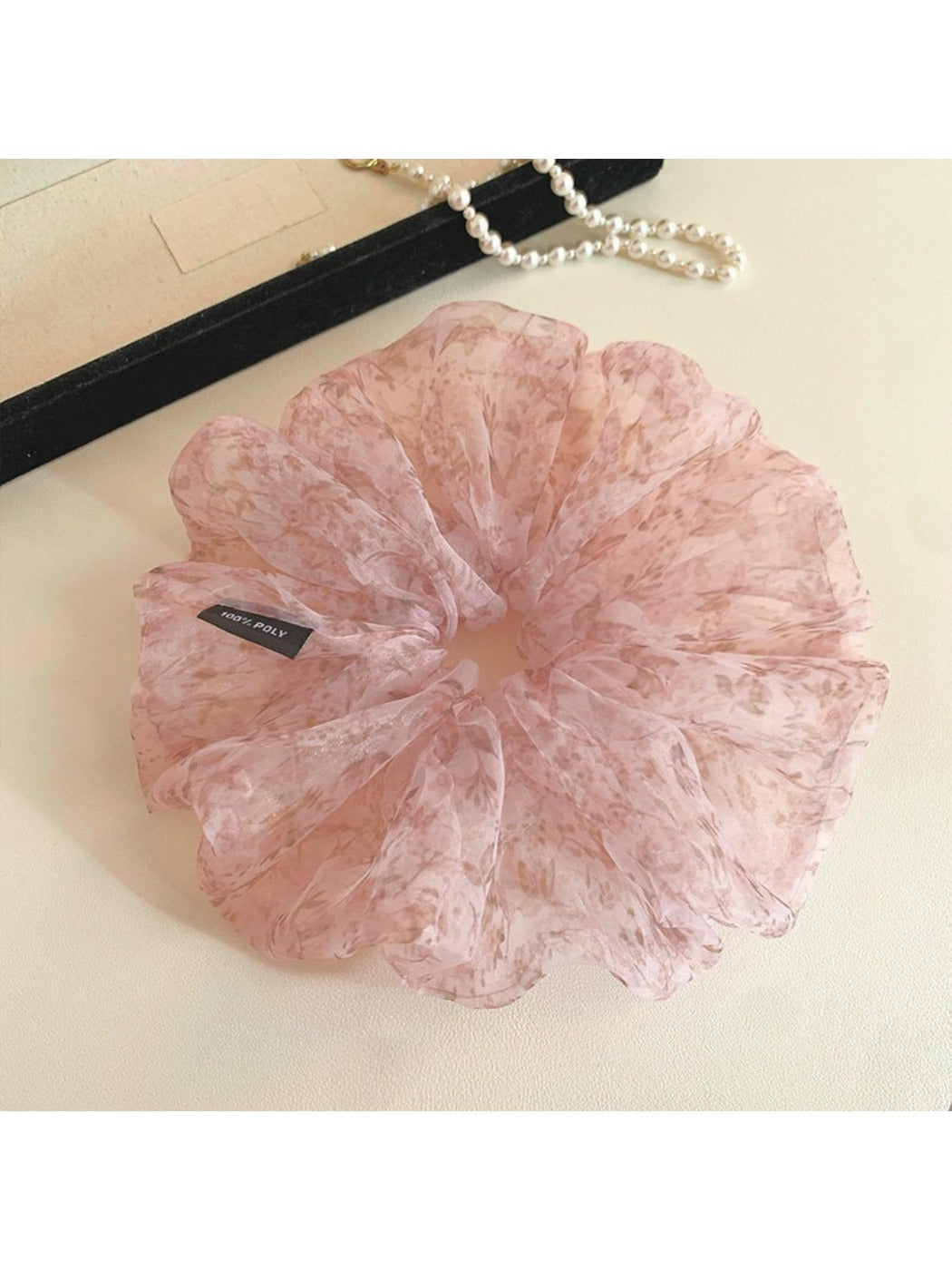 Large pink tulle scrunchie with tiny floral pattern on a white background