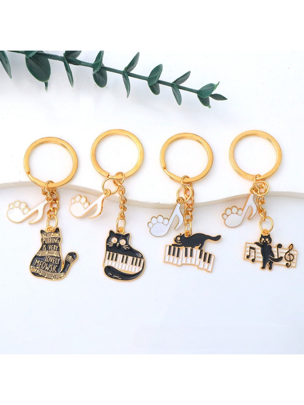 Cartoon cat piano keychain with black and white piano keys on a white background