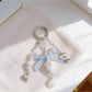 Close-up of floral bow charm showing detailed flower pattern and gold keyring