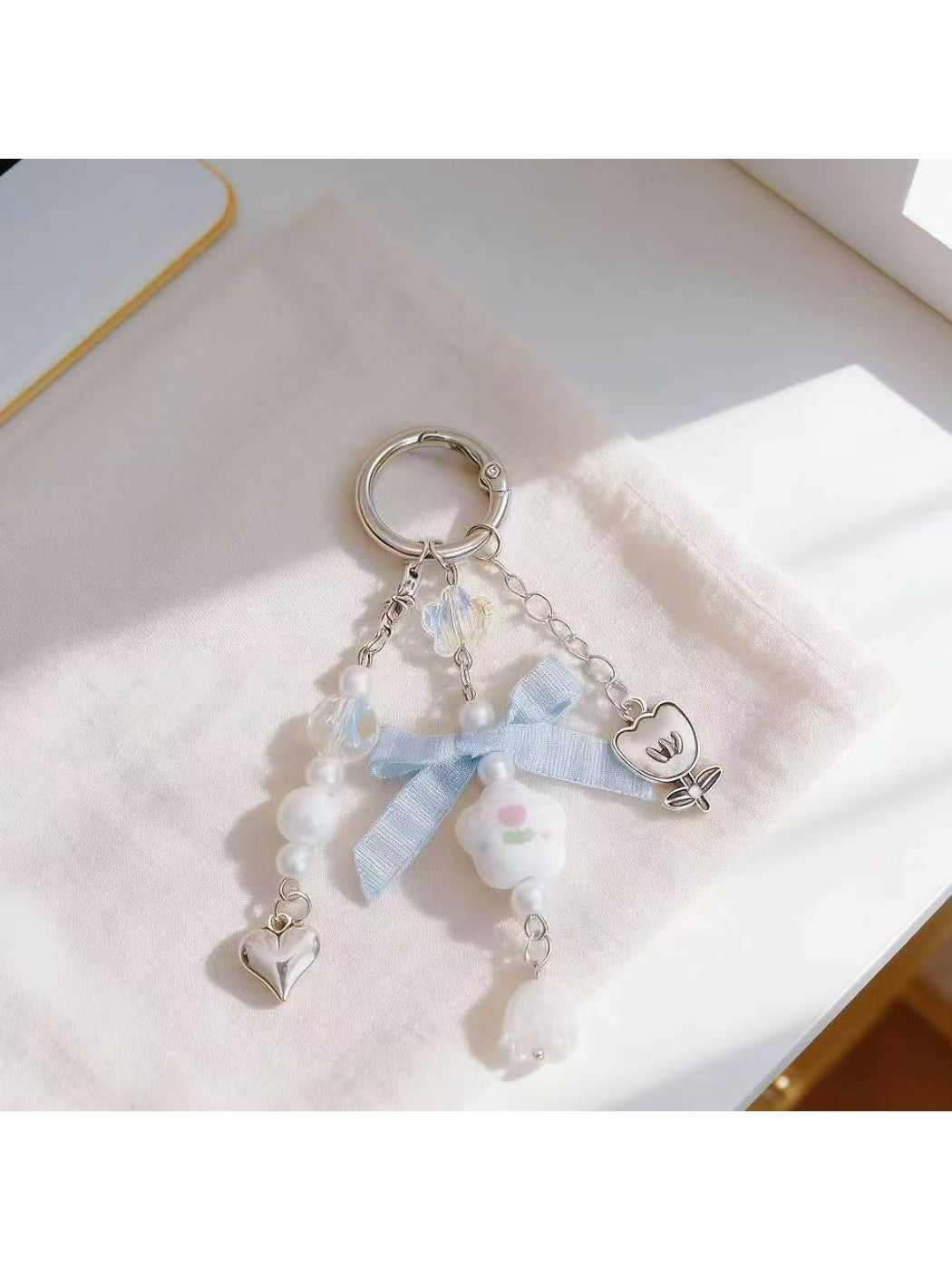 Close-up of floral bow charm showing detailed flower pattern and gold keyring