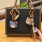 Close-up of a cute bear charm keychain with a smiling face and soft brown fur