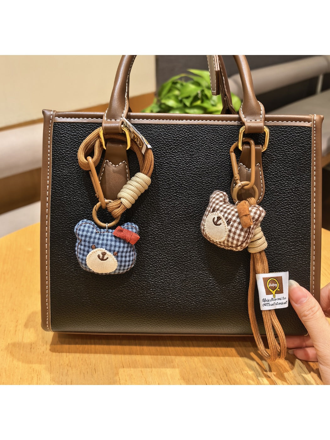 Close-up of a cute bear charm keychain with a smiling face and soft brown fur