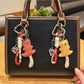 Cute long-tailed bear keychain with soft plush fur and embroidered facial features
