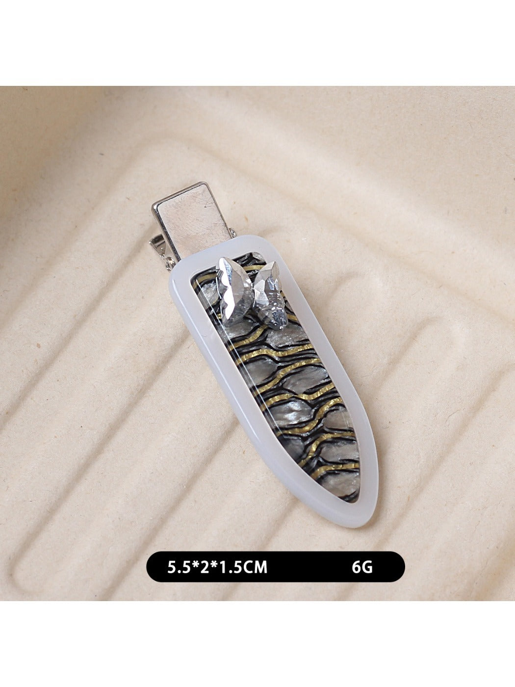 Beau oval butterfly hair clip placed on a wooden surface with natural light