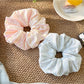 Gifty elegant solid color striped scrunchie in soft beige fabric with subtle stripes