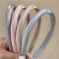 Smooth bright satin headband in vibrant pink displayed on a white background