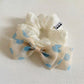 Close-up of Gifty polka dot bow embellished hair tie in black and white