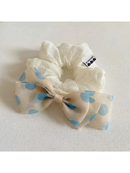 Close-up of Gifty polka dot bow embellished hair tie in black and white