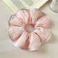 Chic pink striped hair scrunchie on a white background