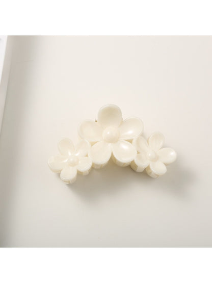 Yellow flower hair clip worn in long brown hair, styled on the side