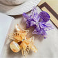 Beau hair claw clip held in hand displaying size and butterfly design