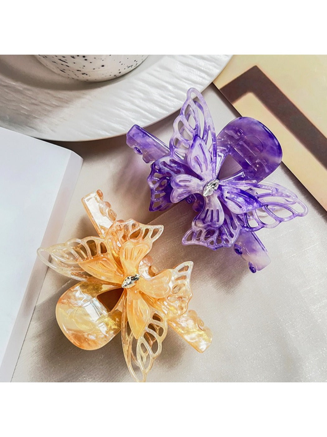 Beau hair claw clip held in hand displaying size and butterfly design