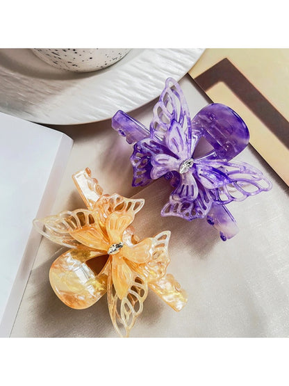 Beau hair claw clip held in hand displaying size and butterfly design