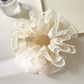 Side view of Gifty embroidered flower scrunchie showing delicate tulle fabric