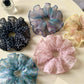 Close-up of Gifty retro style floral scrunchie with pink and green flower pattern