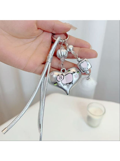 Silver heart keychain attached to a set of keys on a wooden surface