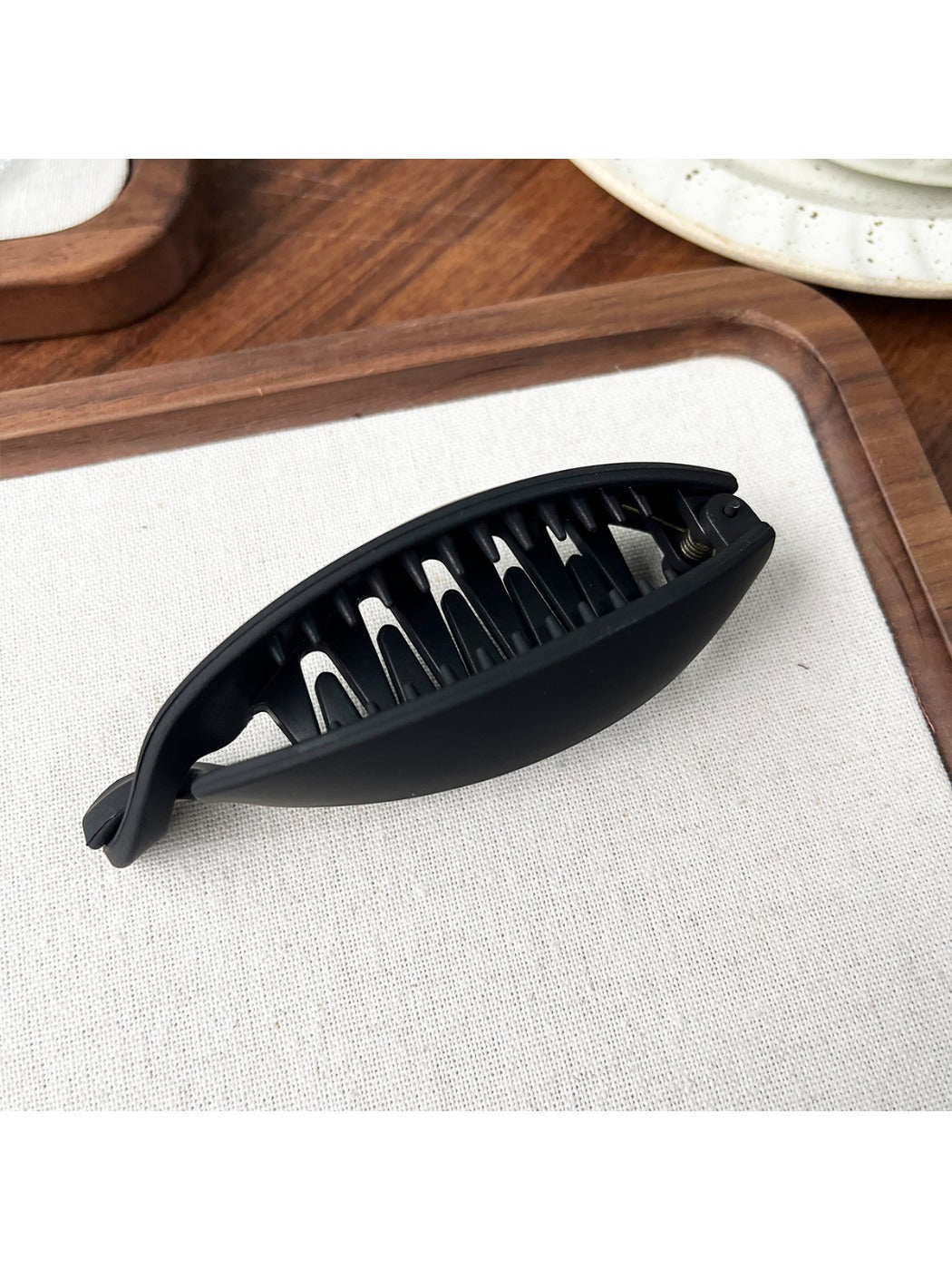 Beau high ponytail hair clip displayed on a wooden surface