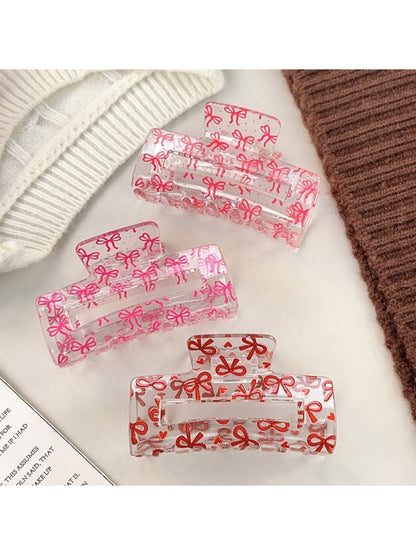 Beau hair claw clip held in hand displaying size and openwork pattern