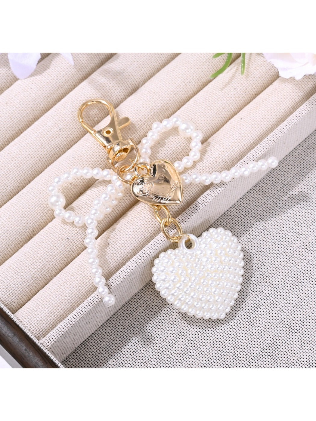 Keypus bow heart shaped keychain displayed on a wooden surface