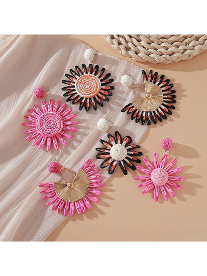 Close-up of pink and black raffia woven earring with gold-tone hoop
