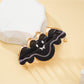 Black bat shaped hair clip with detailed wings on a white background