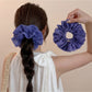 Side view of ruffled scrunchie showing fabric texture and polka dot pattern