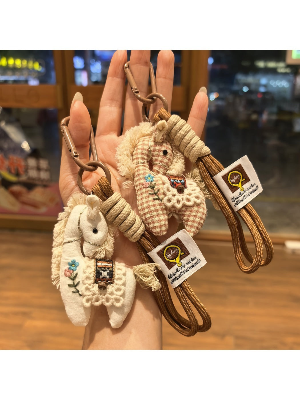 Side view of fabric pony bag charm with metal keyring attached