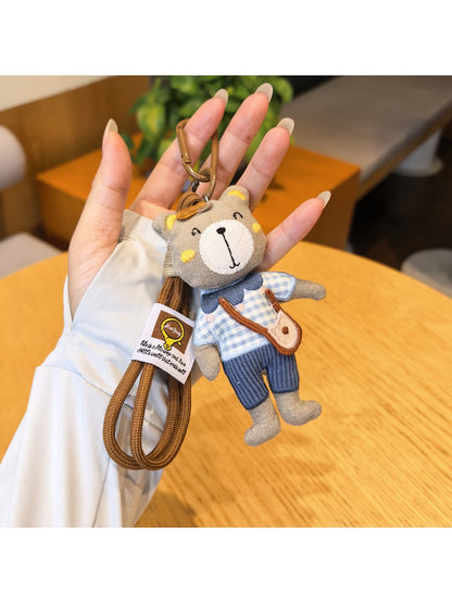 Close-up of a trendy bear charm keychain with a gold ring and brown bear figure