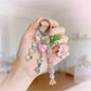 Keypus beaded heart charm keychain attached to a set of keys on a wooden surface