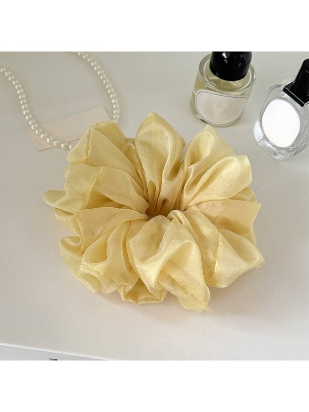 Scrunchie wrapped around a ponytail on a model with dark hair