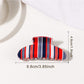 Beau half moon claw clip with bright multicolor stripes on neutral background