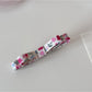 Beau hair clip held in hand showing scale and floral print details