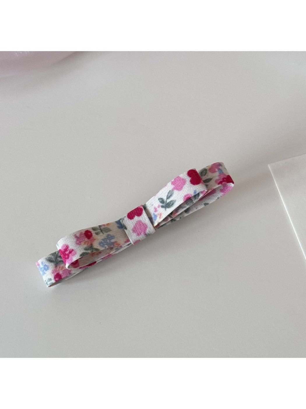 Beau hair clip held in hand showing scale and floral print details