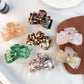 Beau bow shaped claw clip in glossy tortoiseshell pattern on white background