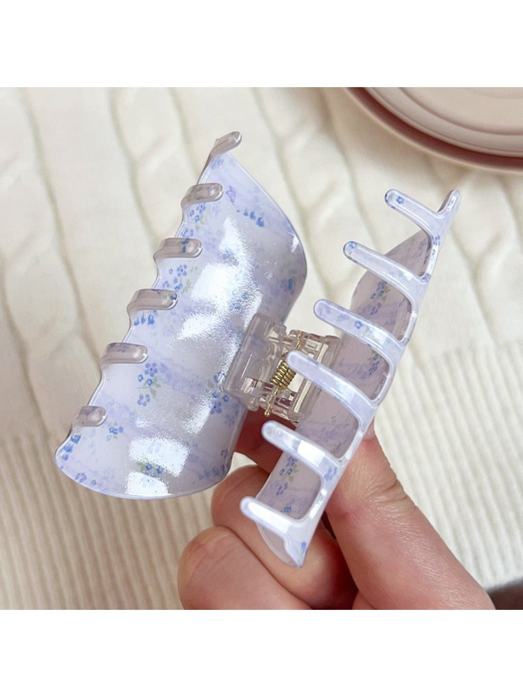 Beau hair claw clip open, displaying inner teeth and floral design
