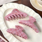 Beau pink plaid crescent claw clip held in hand for size reference