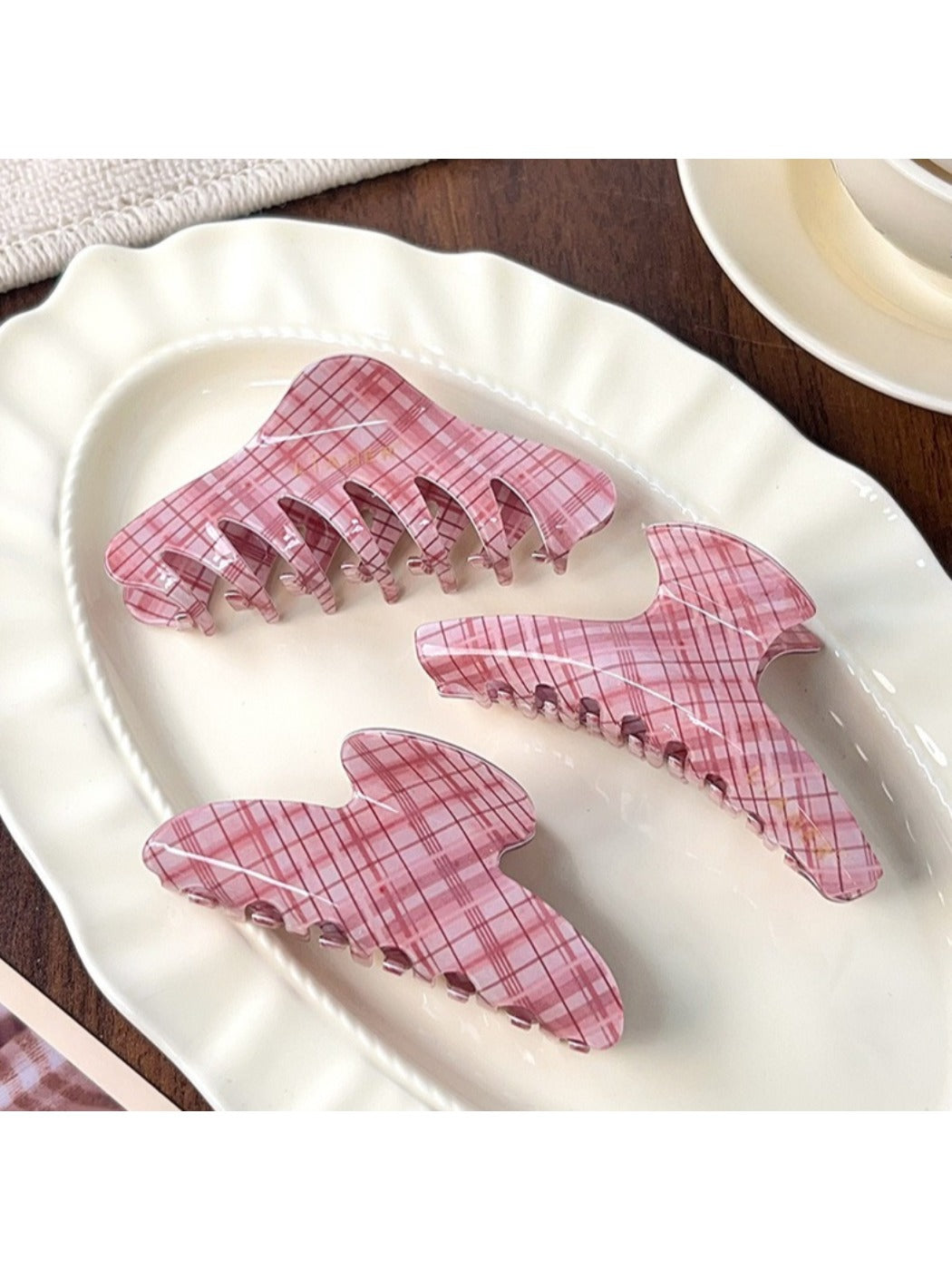 Beau pink plaid crescent claw clip held in hand for size reference