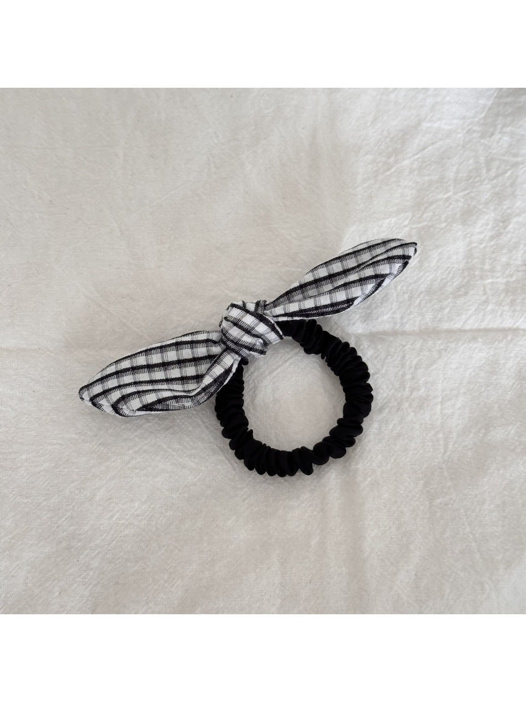 Gifty hair tie with red bow embellishment shown in natural light on a white background