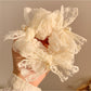 Chic white lace bow scrunchie on a plain background