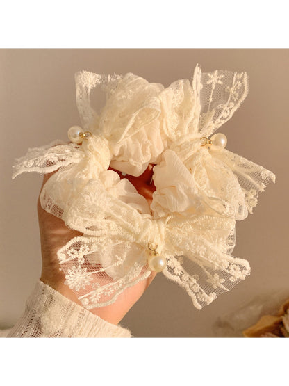 Chic white lace bow scrunchie on a plain background