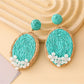 Detailed shot of the woven raffia pattern on Earedge oval shape earrings