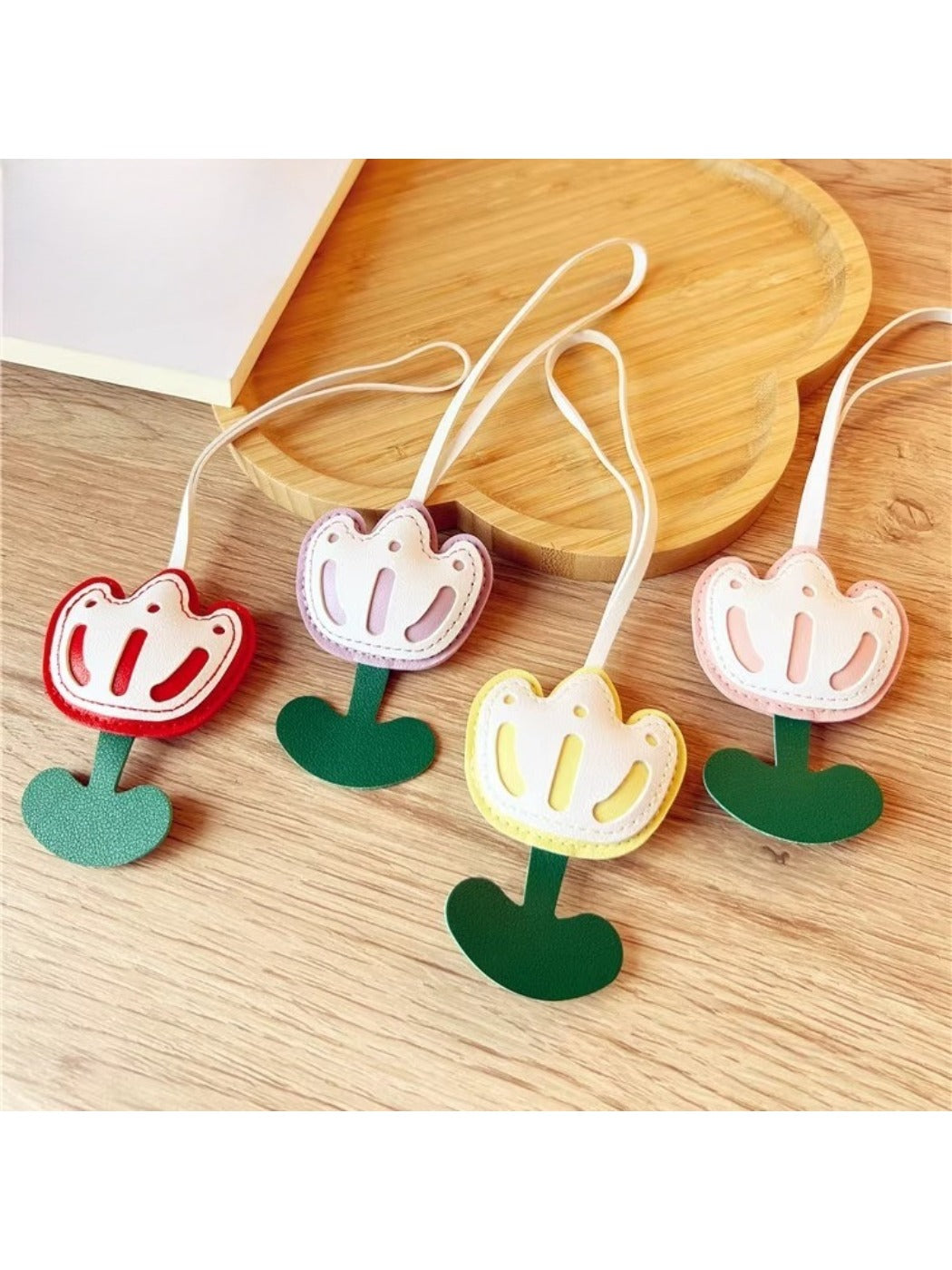 Close-up of a pink tulip-shaped bag charm keychain with gold hardware