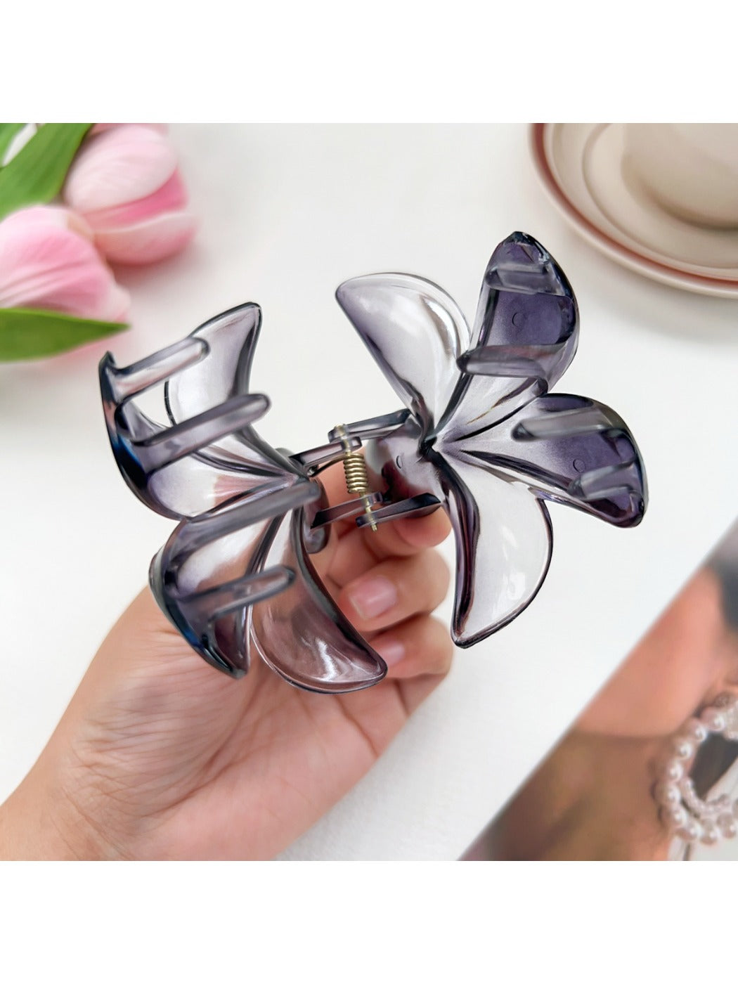 Beau flower claw clip held in hand displaying size and vibrant colors