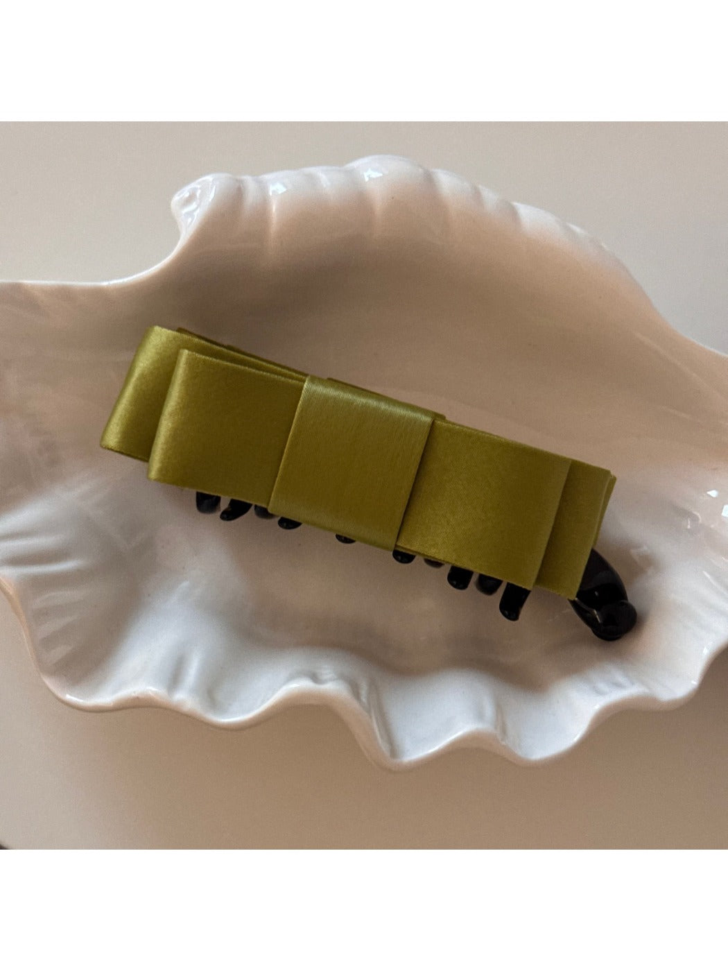 Beau bow hair clip held in hand to show size and scale