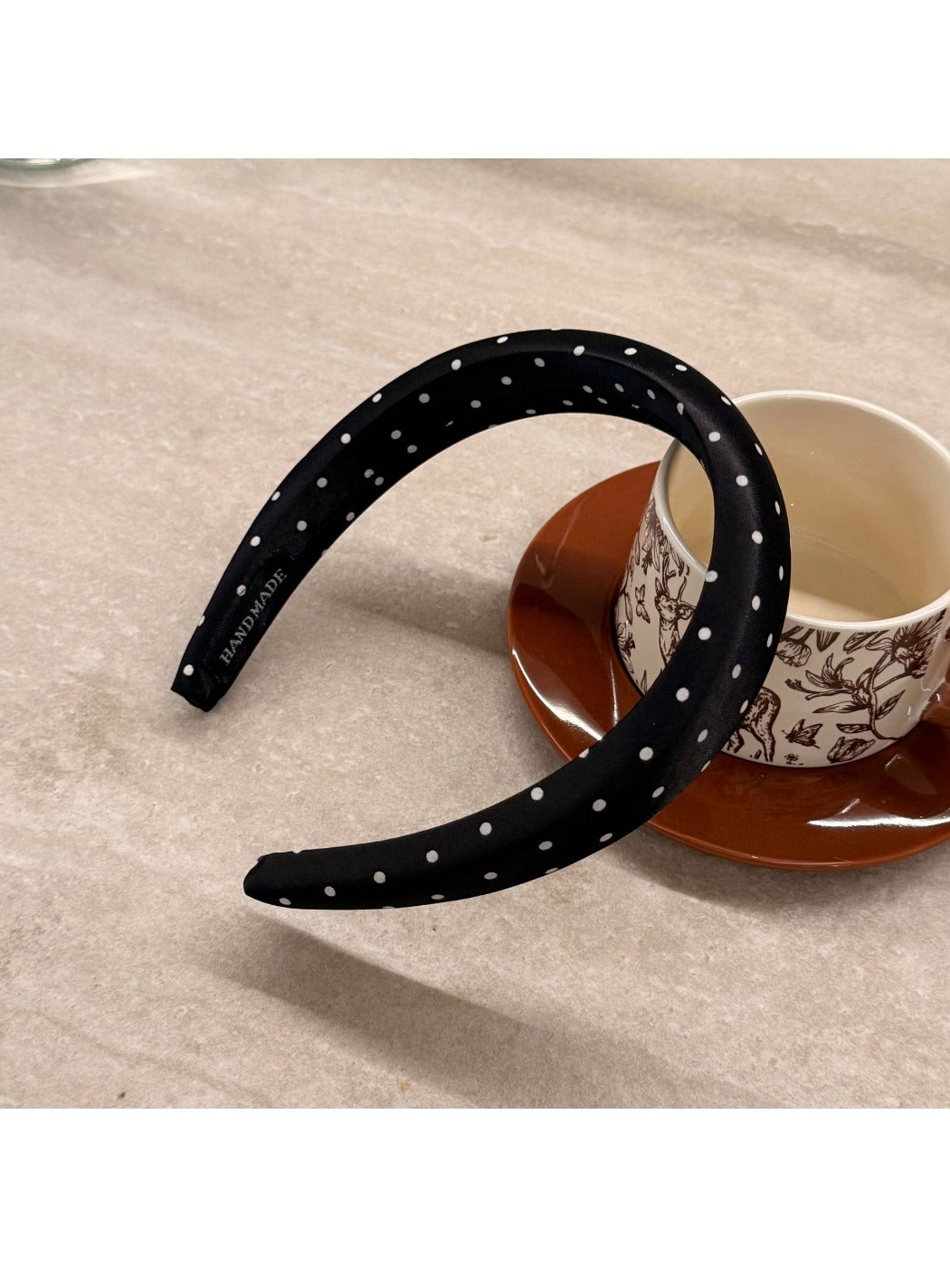 Pink wide edge headband with white polka dots styled on a white background
