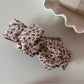 Back view of Beau floral bow hair clip showing metal clip mechanism