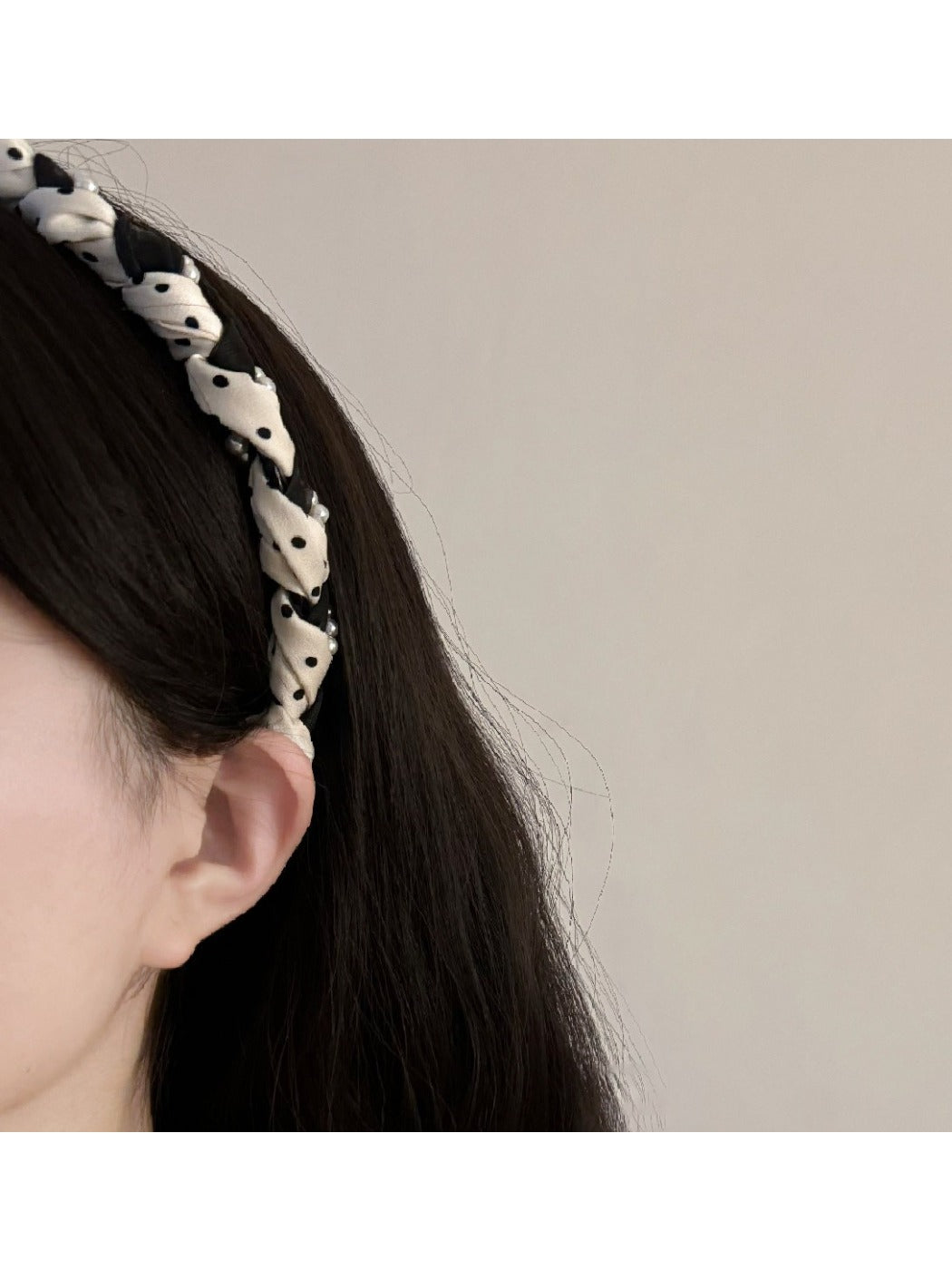 Black and white braided fabric headband with a twisted knot design