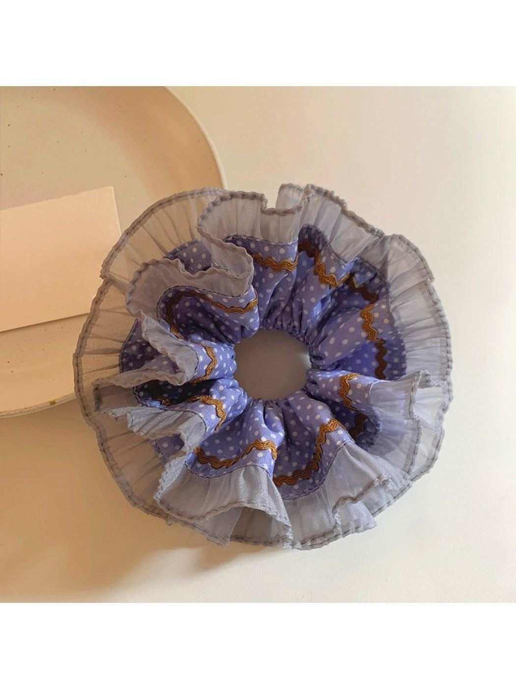 Close-up of Gifty scrunchie showing delicate lace trim and polka dot pattern