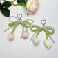 Minimalist bow and tulip pendant keychain on a white background
